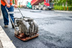 asphalt worker at road repairing and construction site